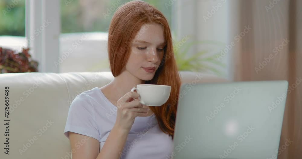 Attractive woman working on laptop at home drinking coffee. tracking shot. real time. Shot on Canon 1DX mark2 4K camera Attractive woman working on laptop at home drinking coffee. tracking shot. real time. Shot on Canon 1DX mark2 4K camera