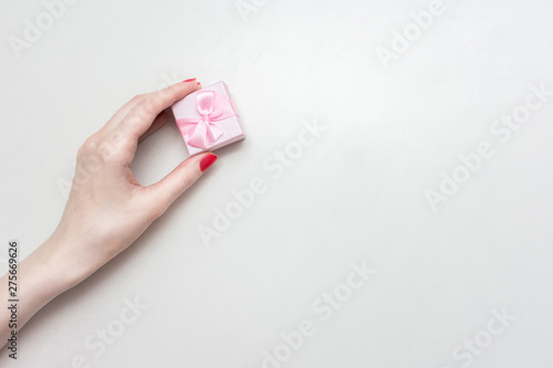 Woman's hand with a pink square gift box,  background, copy space, for text