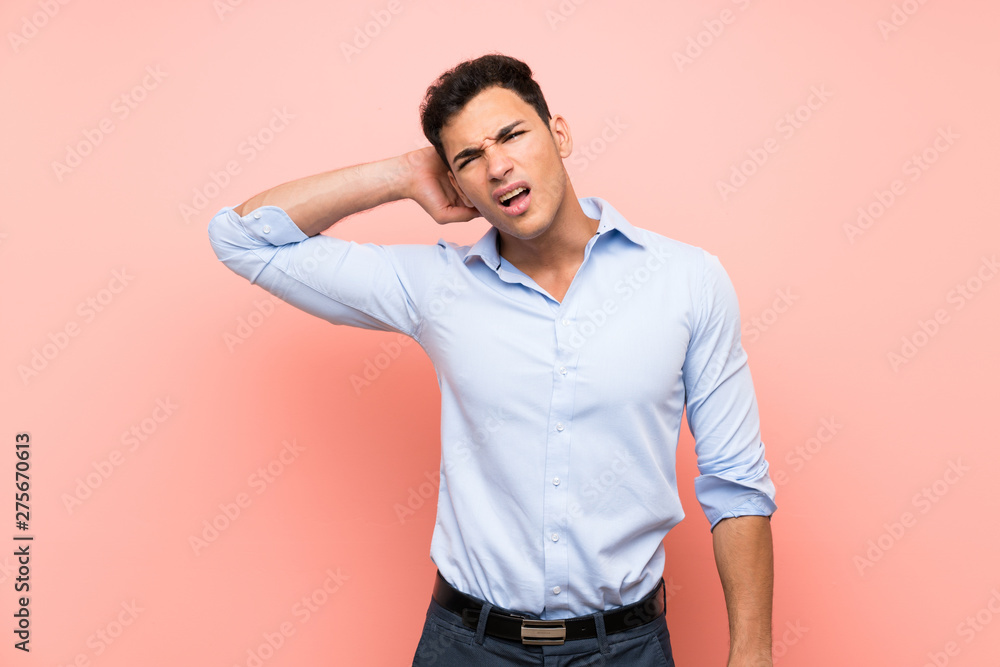 Handsome man over pink background with neckache Handsome man over pink background with neckache