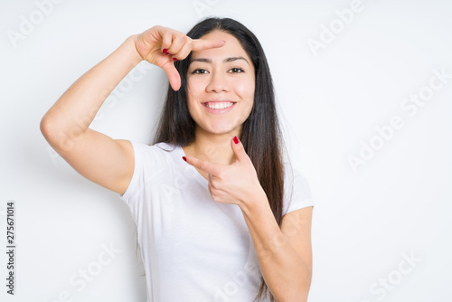 Wallpaper Mural Beautiful brunette woman over isolated background smiling making frame with hands and fingers with happy face. Creativity and photography concept. Torontodigital.ca