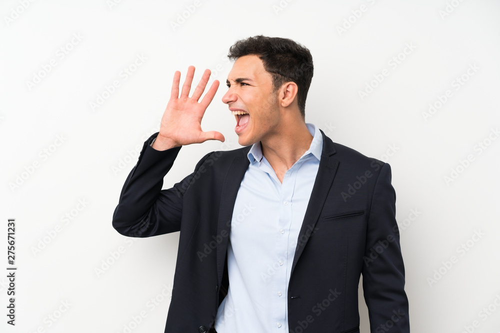 Handsome man over isolated white wall shouting with mouth wide open