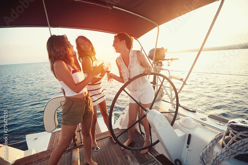 .young women have fun on the yacht at sunset. . © luckybusiness