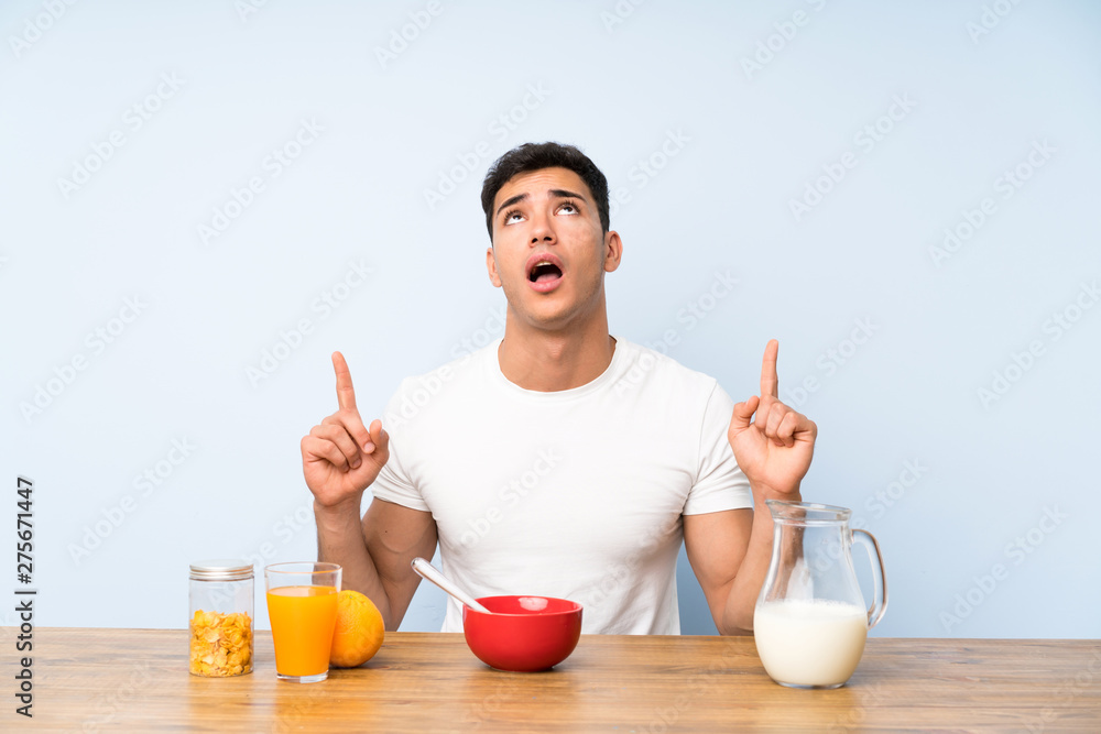 Handsome man in having breakfast pointing with the index finger a great idea Handsome man in having breakfast pointing with the index finger a great idea