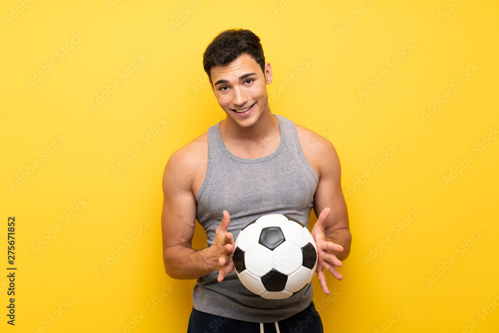 Handsome sport man over isolated background with a soccer ball Handsome sport man over isolated background with a soccer ball