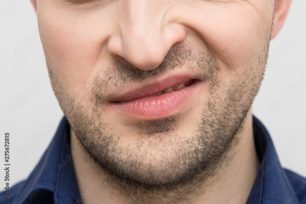 Grimace of irritation or discontent on the face of a bearded male, close up, cropped image Grimace of irritation or discontent on the face of a bearded male, close up, cropped image