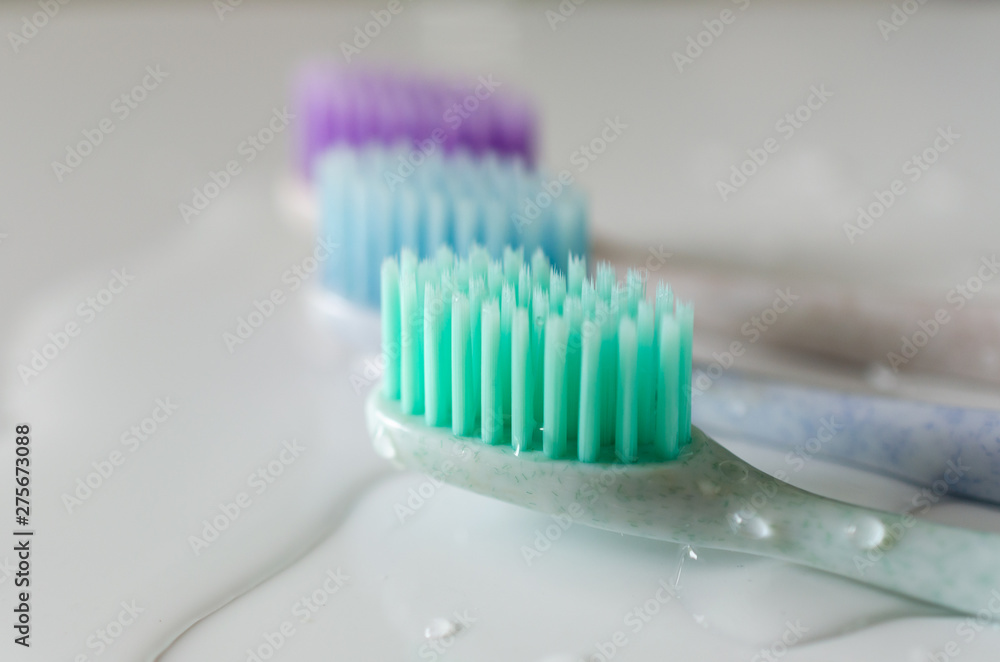 three toothbrushes of different colors on white background. three toothbrushes of different colors on white background.