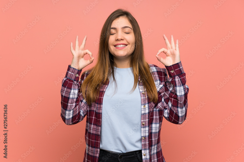 Young girl over pink wall in zen pose Young girl over pink wall in zen pose