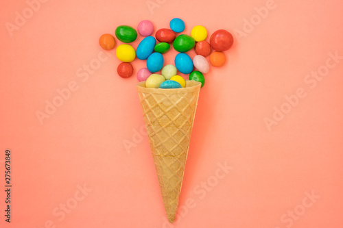 Waffle horn with candy on pink background