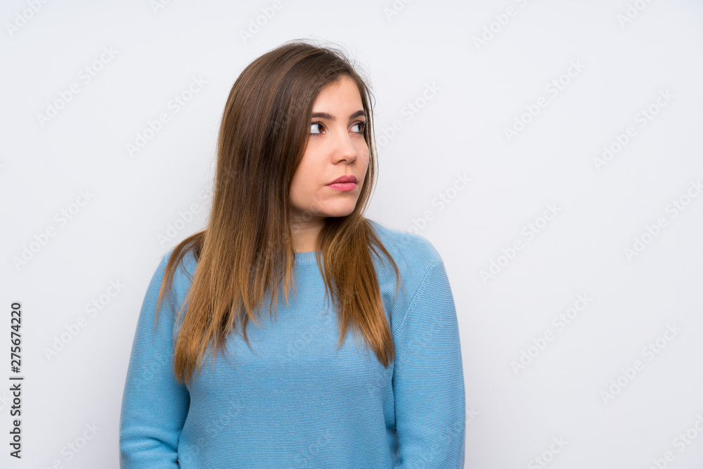 Young girl with blue sweater standing and looking side Young girl with blue sweater standing and looking side