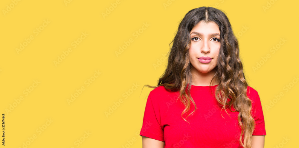 Young beautiful woman wearing casual t-shirt Relaxed with serious expression on face. Simple and natural looking at the camera. Young beautiful woman wearing casual t-shirt Relaxed with serious expression on face. Simple and natural looking at the camera.