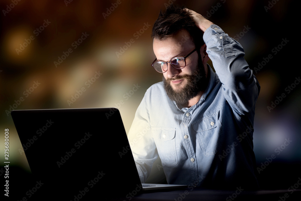 Young handsome businessman working late at night in the office Young handsome businessman working late at night in the office