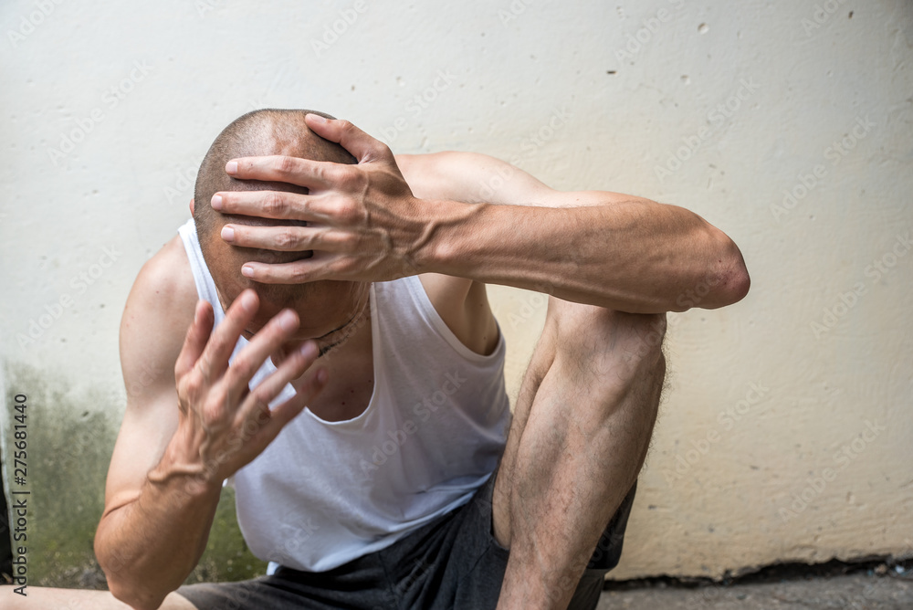 Foto Stock Young poor skinny anorexic bald homeless man sitting on the ...