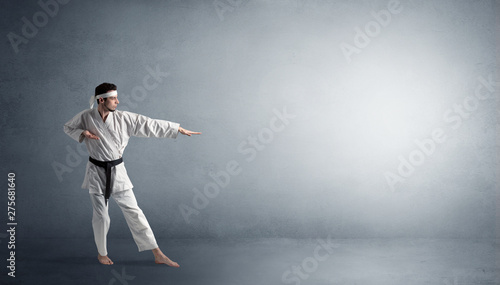 Small karate man fighting in an empty grey copy space © ra2 studio