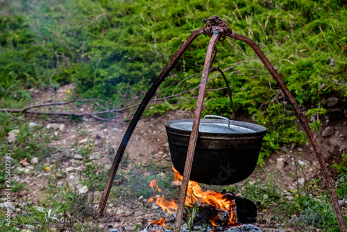 Cauldron or camping kettle over open fire outdoors