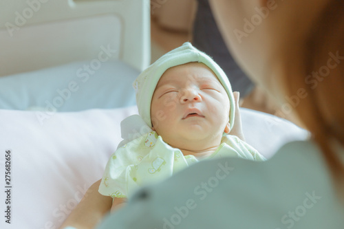 Newborn baby boy sleeping in asian mother hand at hospital