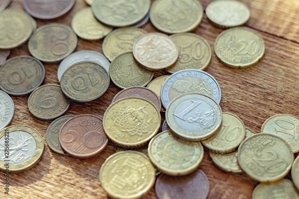 coins old rusty brass euro Seychelles Bulgaria China Germany pile pack heap stack on a wooden background finance economy investment savings concept mock up selective focus close up