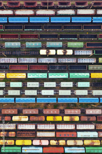 Aerial view of freight trains on the railway station. Cargo trains close-up. Wagons with goods on railroad. Industrial conceptual scene with trains. Top view.