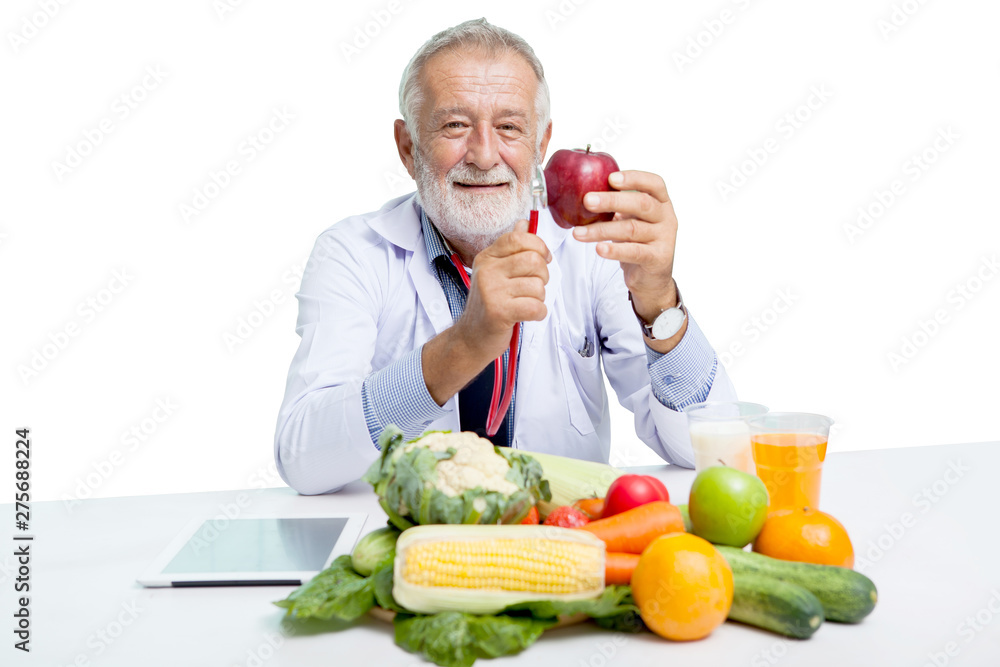 senior doctor male nutritionist holding stethoscope and red apple with Vegetables,Juice,fruit,milk while sitting at table on white background, elderly man dietitian with clipping path senior doctor male nutritionist holding stethoscope and red apple with Vegetables,Juice,fruit,milk while sitting at table on white background, elderly man dietitian with clipping path