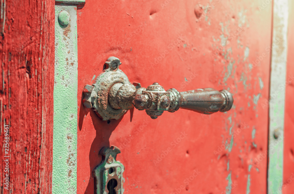 Antique metal handle on the red door Antique metal handle on the red door