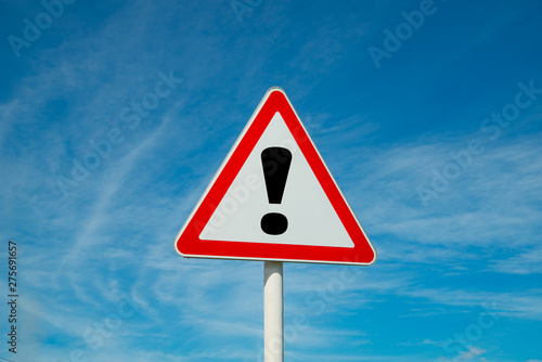 Exclamation point of attention against the sky. triangular sign. Danger, warning.
