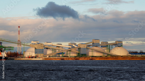 Oil terminal at river mouth on blue sky and clouds background