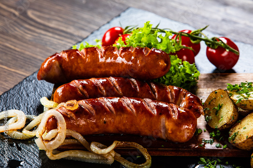 Grilled sausages and vegetables on cutting board