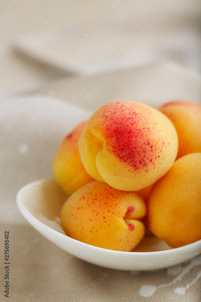 Ripe apricots on a white plate on a light background Ripe apricots on a white plate on a light background