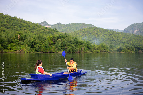 Asian couple rowing boat in river
