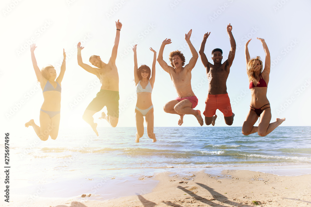 Happy smiling friends jumping at the beach Happy smiling friends jumping at the beach