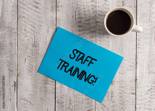 Obraz na płótnie Text sign showing Staff Training. Business photo showcasing learn specific knowledge improve perforanalysisce in current roles Pastel Colour paper placed next to a cup of coffee above the wooden table w salonie