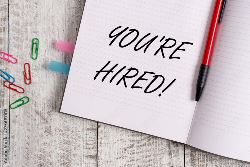 Conceptual hand writing showing You Re Hired. Concept meaning Used by huanalysis resources indicate employee that he is got job Notebook stationary placed above classic wooden backdrop Conceptual hand writing showing You Re Hired. Concept meaning Used by huanalysis resources indicate employee that he is got job Notebook stationary placed above classic wooden backdrop