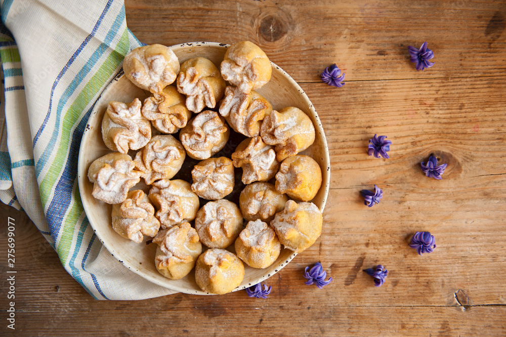 Homemade biscuit with violet hyacinth, white flower and yellow taraxacum on the wooden table