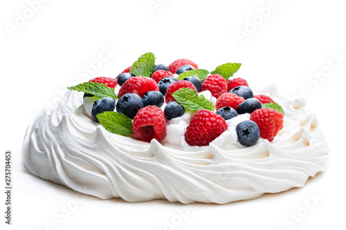 Pavlova meringue nest with berries and mint leaves isolated on white photo