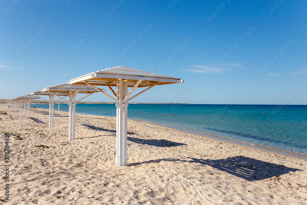 Fototapeta premium No people beach. Clear sea and cloudless sky. Umbrella.