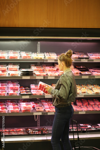 Quadro su tela Woman purchasing a packet of meat at the supermarket