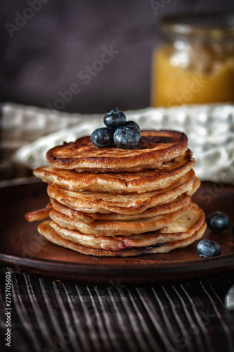 Pancakes with blueberry and honey. On a wooden table with a white towel