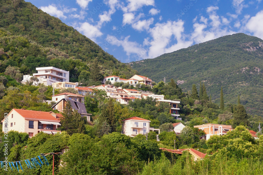 Summer vacation in the village. Beautiful summer landscape with a small village on the mountainside on a sunny day. Montenegro, Tivat, Donja Lastva village