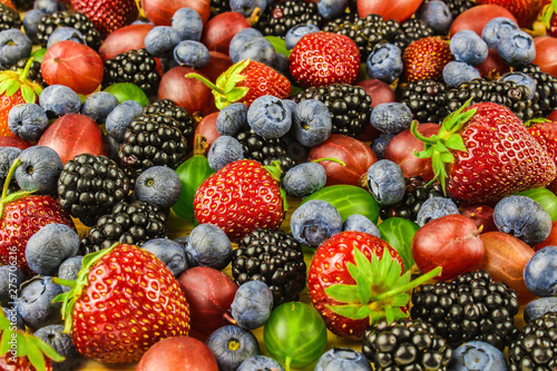 Fototapeta Naklejka Na Ścianę i Meble -  Background from fresh fruits and berries. Ripe blackberries, strawberries, gooseberries, blueberries. Mix berries and fruits. View from above. Background berries and fruits.