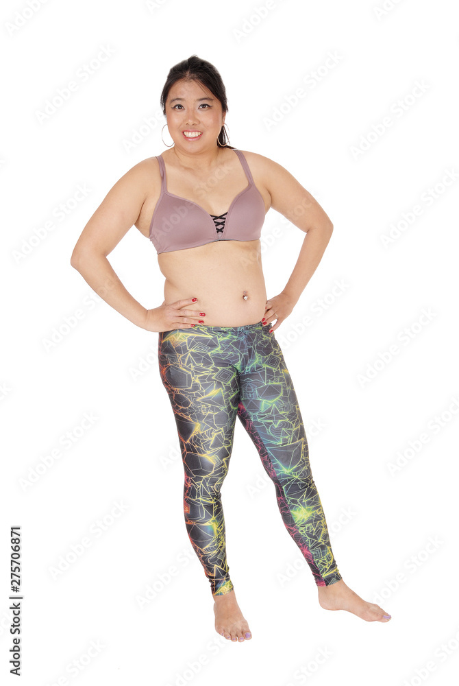 Lovely Asian woman standing in sports bra and leggings