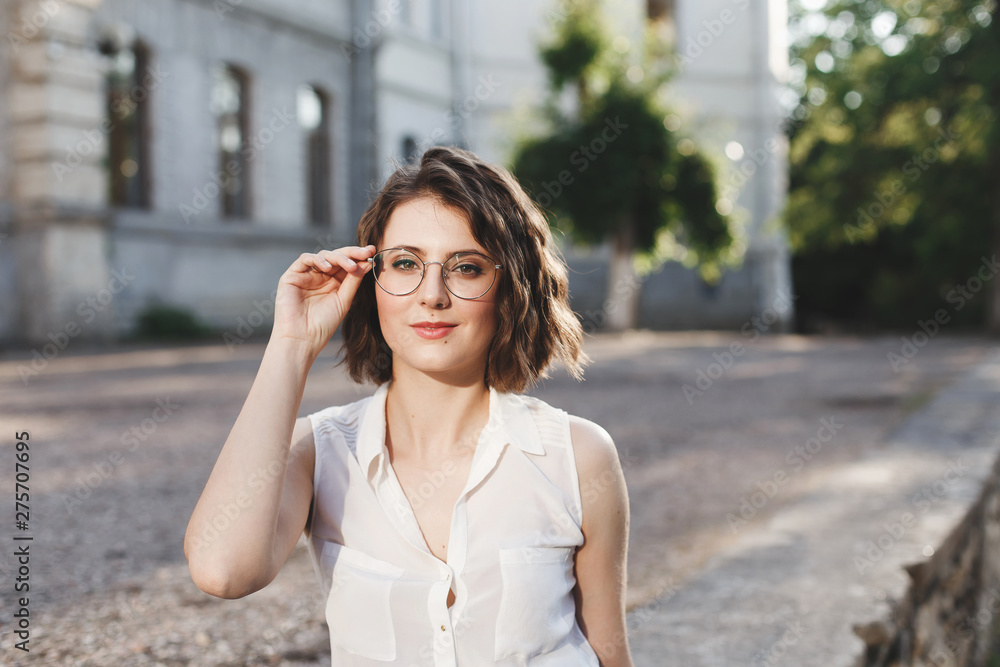 Portrait of beautiful young brunette woman in glasses, outdoors in warm sunny day. Portrait of beautiful young brunette woman in glasses, outdoors in warm sunny day.
