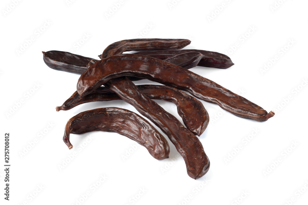 Carob pods on the white background, close-up. Carob pods on the white background, close-up.