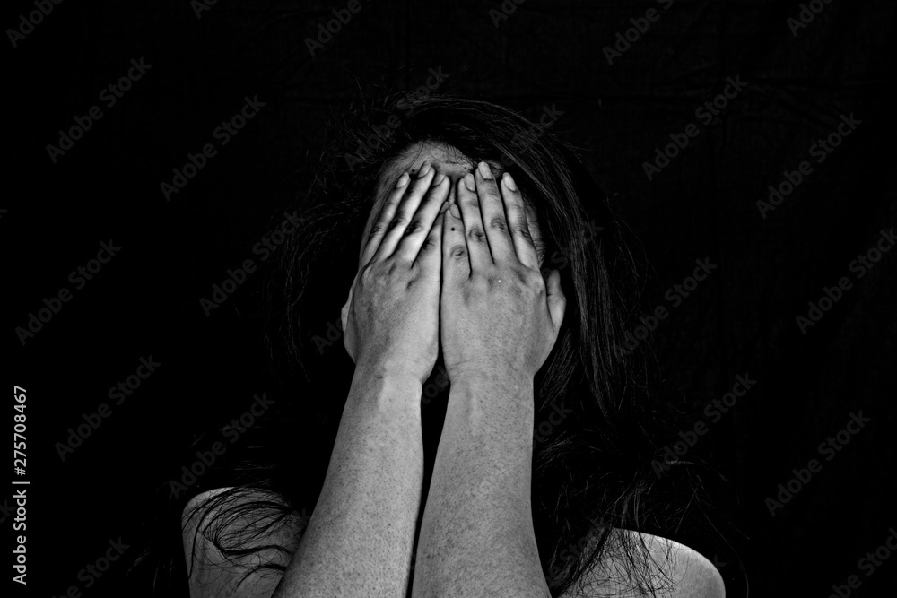 Stopping violence against women, Woman covering her face in fear of domestic violence, Dark tone Stopping violence against women, Woman covering her face in fear of domestic violence, Dark tone
