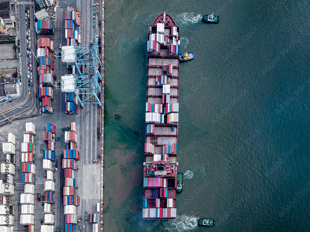 Aerial photo of a large container ship unberthing from terminal