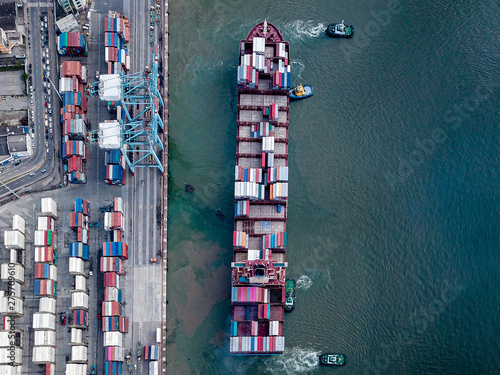 Aerial photo of a large container ship unberthing from terminal