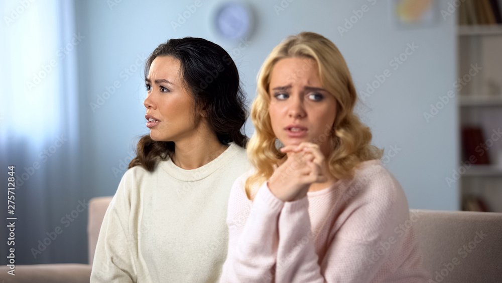 Worried woman being afraid to confess her friend, secret information, shame Worried woman being afraid to confess her friend, secret information, shame