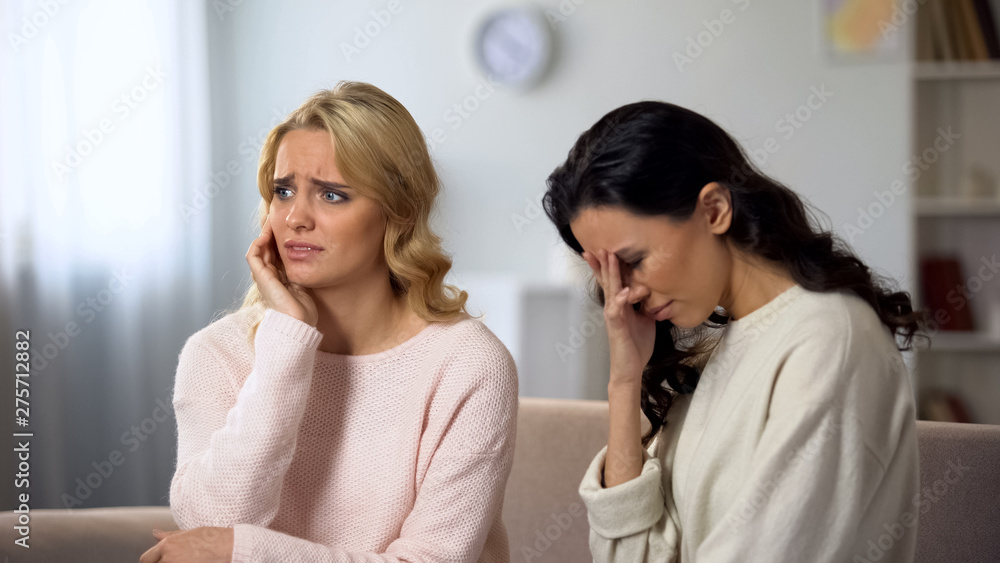 Worried Asian woman telling bad shocked news to her best friend, sharing secret Worried Asian woman telling bad shocked news to her best friend, sharing secret