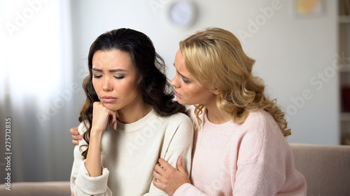 Woman hugging and supporting depressed friend, braking up with boyfriend