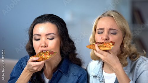 Hungry female friends enjoying delicious pizza  Italian cuisine  food delivery