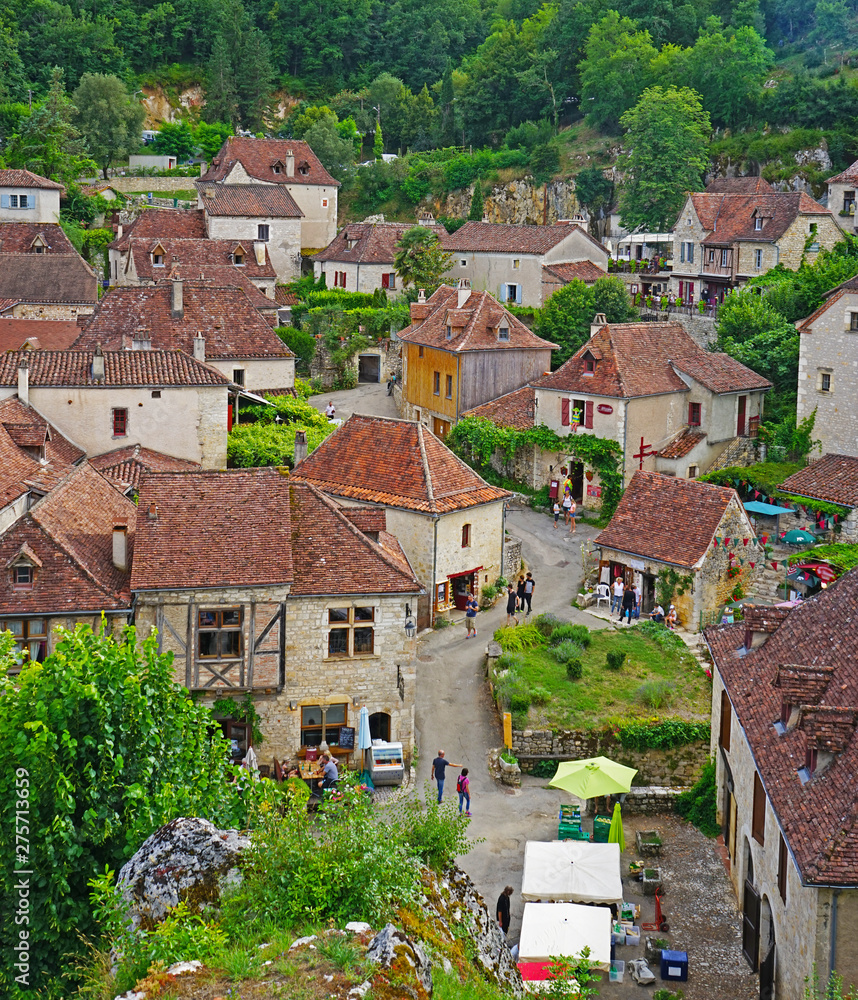 A village from old stone houses, seen from above. People in the village. Saint-Cirq-Lapopie, France