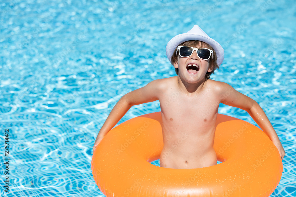 young child smiling in the pool with float and glasses